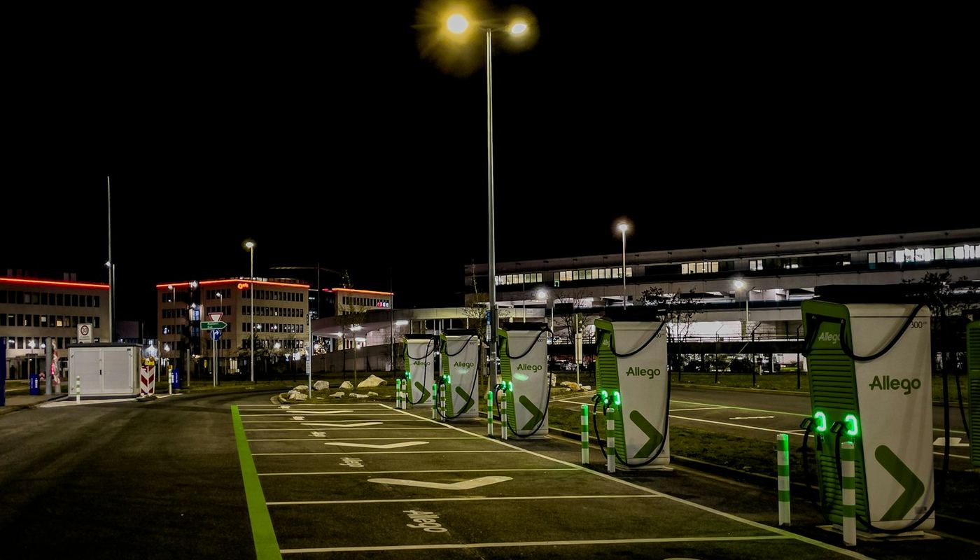Row of commercial EV charging pedestals in a car park