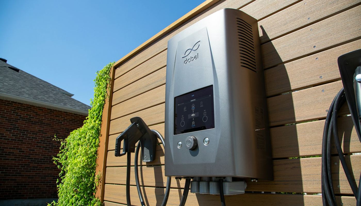 Wall-mounted home EV charger beside a house